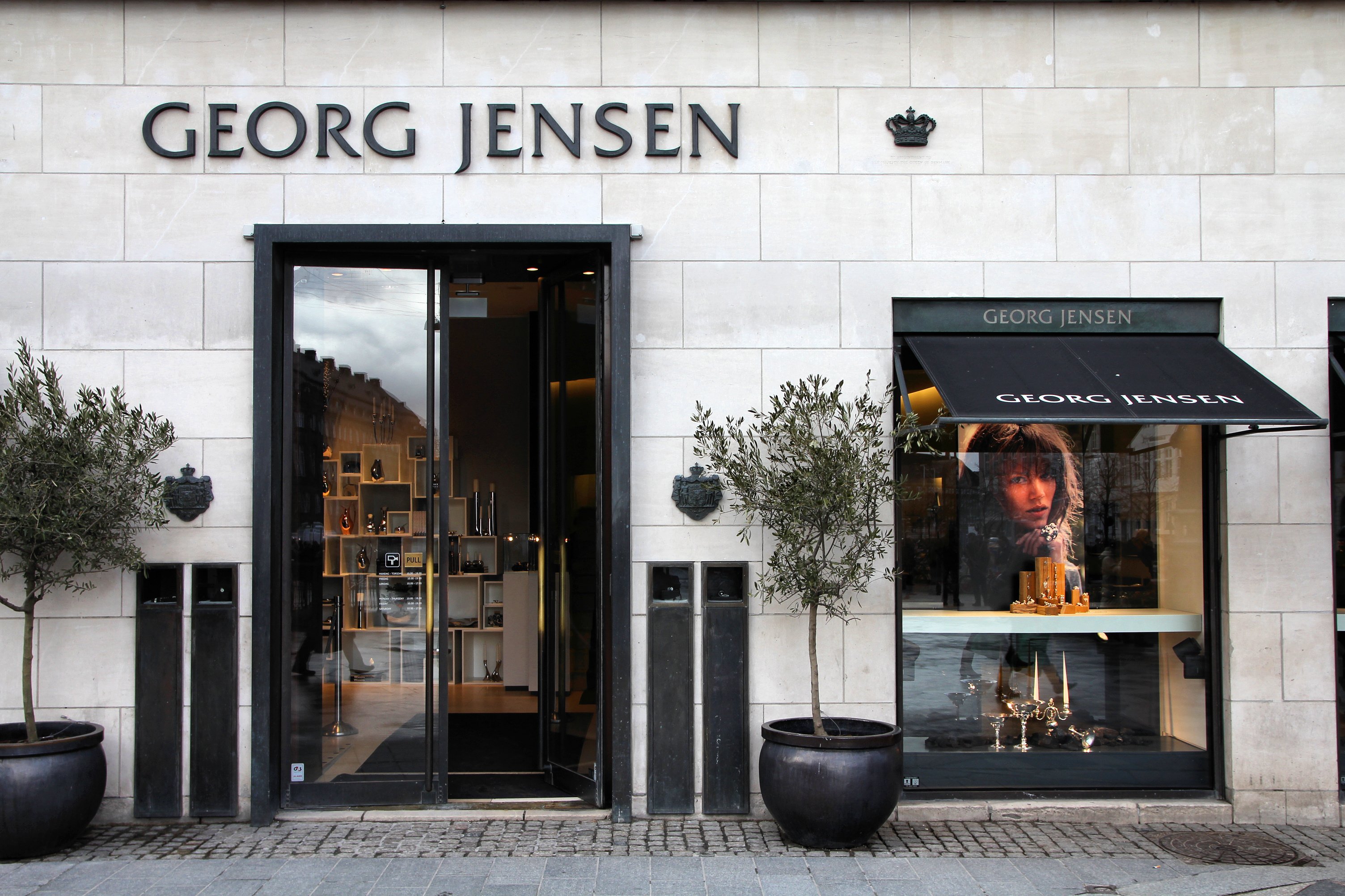 Eksteriør af en Georg Jensen-butik med stort udstillingsvindue og brandskiltning over indgangen.