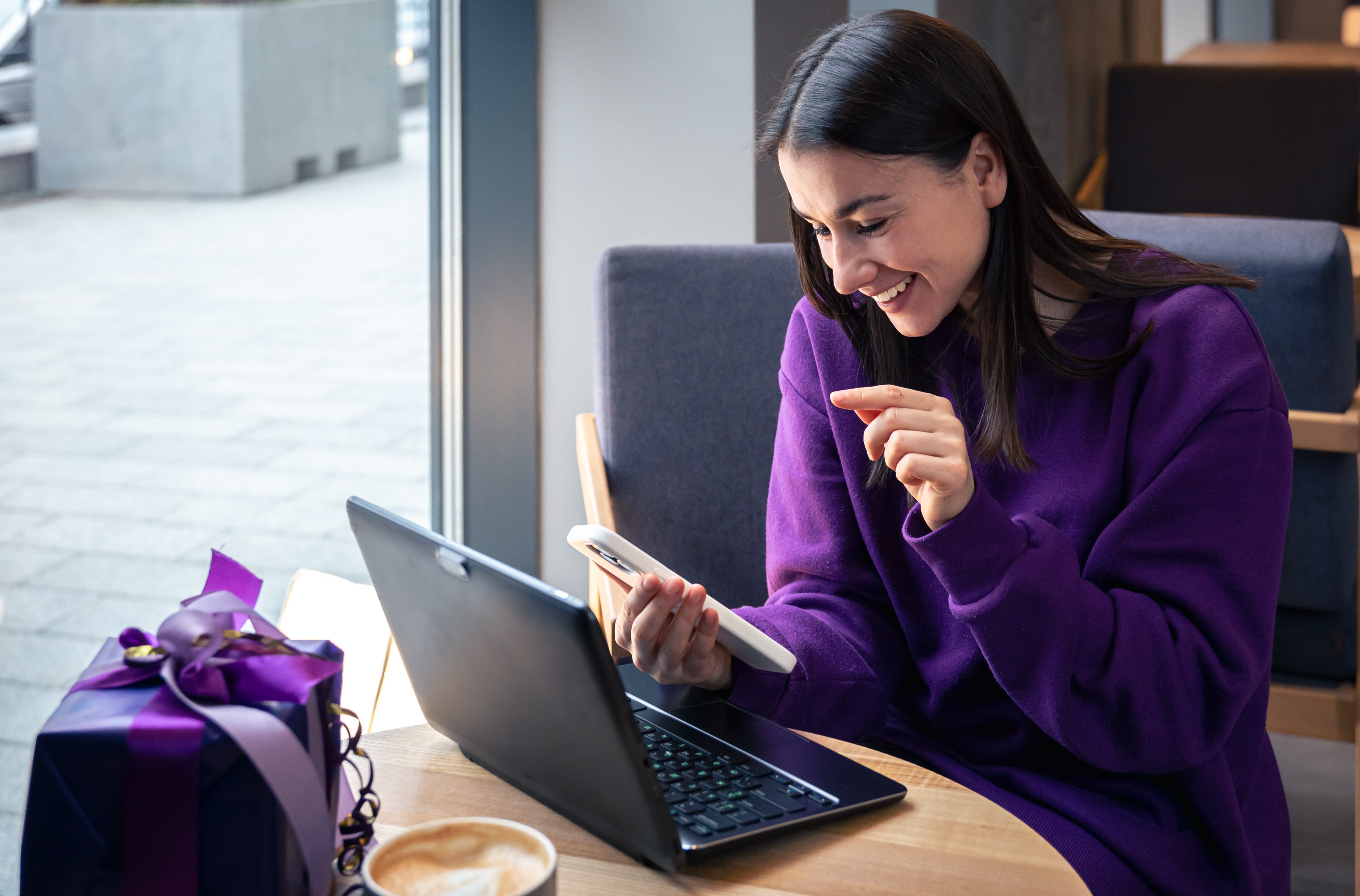 young-woman-uses-smartphone-laptop-cafe-holiday-concept