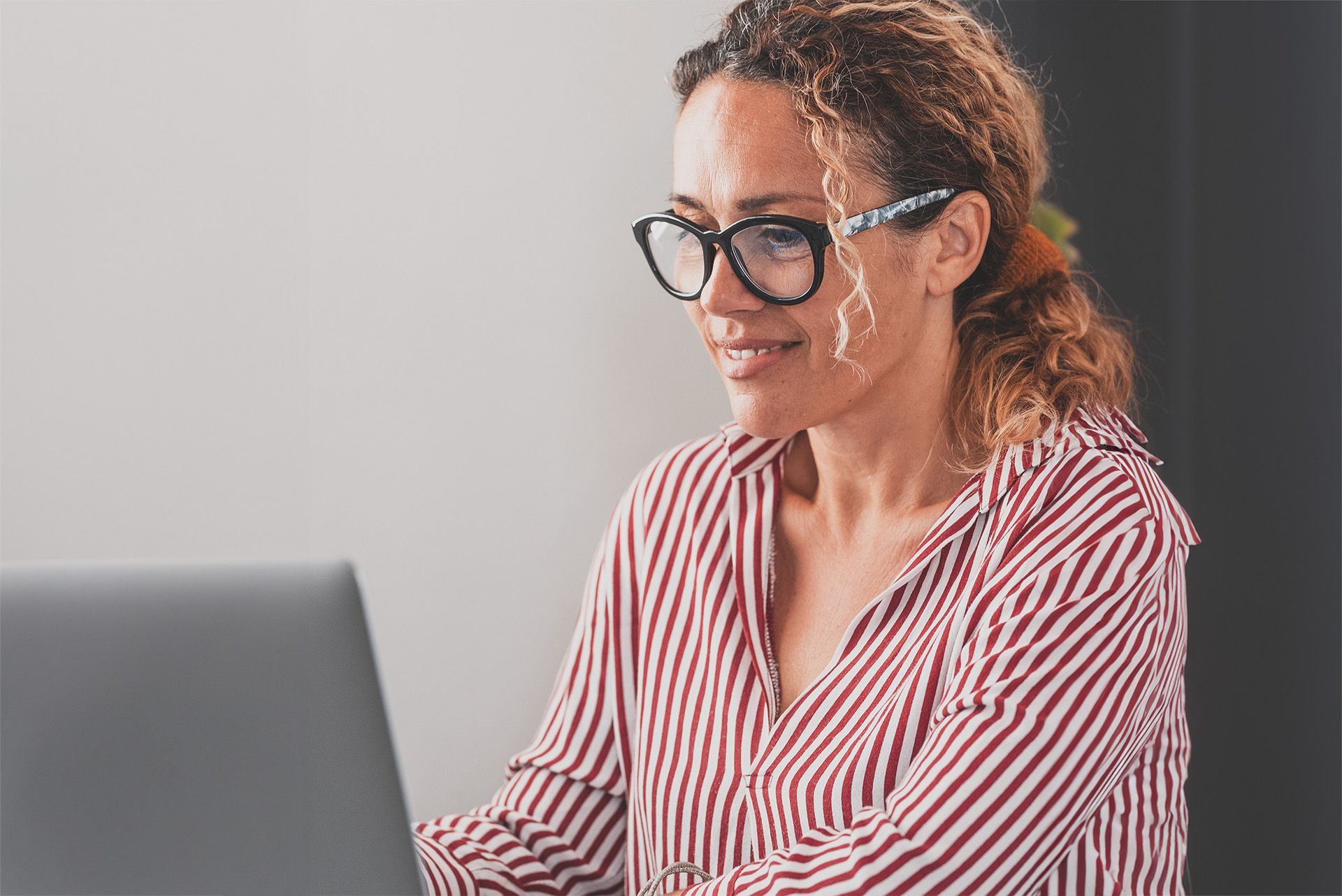 smiling-businesswoman-using-laptop-office_resized